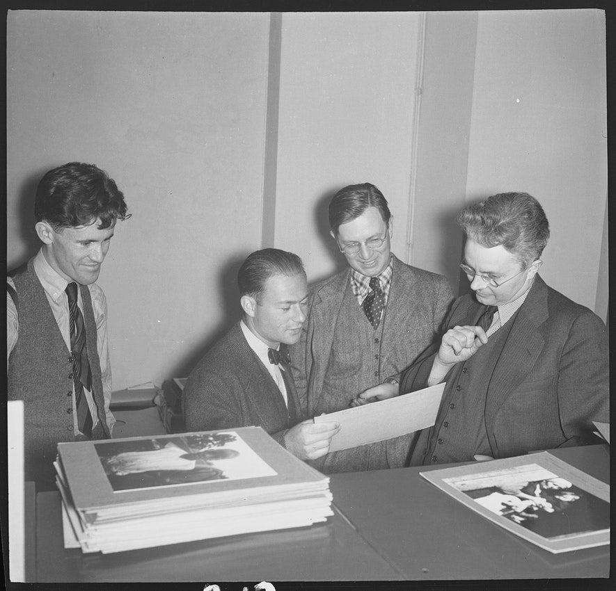 Roy Stryker（最右邊）與 Russell Lee、Arthur Rothstein 和 John Vachon（最左邊）一起回顧照片，約攝於1938年。